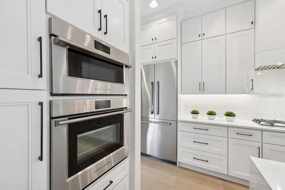 7346 Edenmore Street Lakewood Ranch, FL 34202 - Photo 18 of 70 a kitchen with cabinets stainless steel appliances and wooden floor