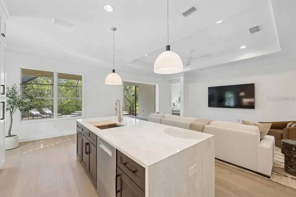 7346 Edenmore Street Lakewood Ranch, FL 34202 - Photo 24 of 70 a kitchen with a stove a sink a microwave a counter and chairs