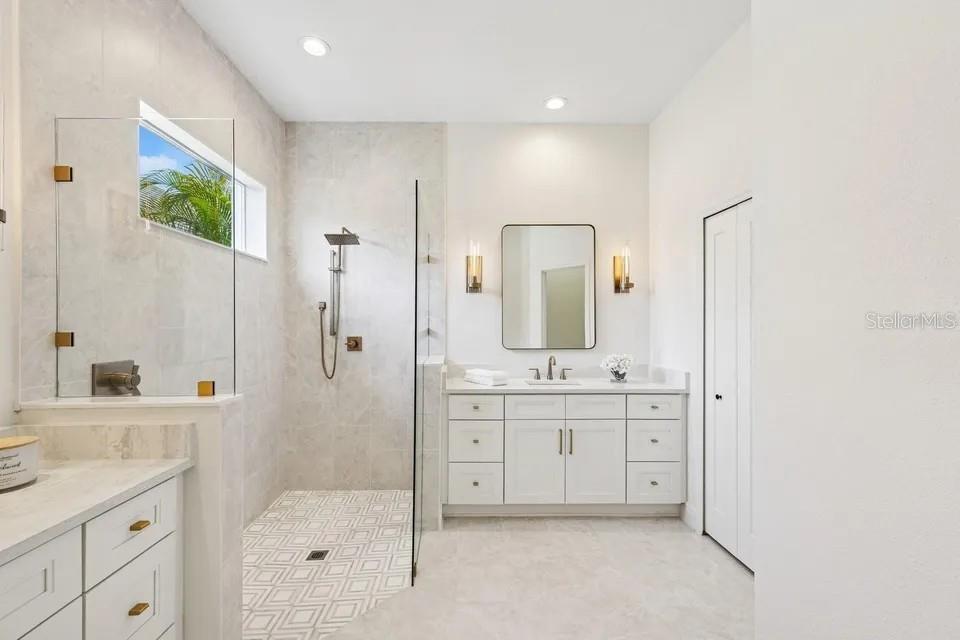 7346 Edenmore Street Lakewood Ranch, FL 34202 - Photo 8 of 70 a spacious bathroom with a granite countertop sink mirror and a