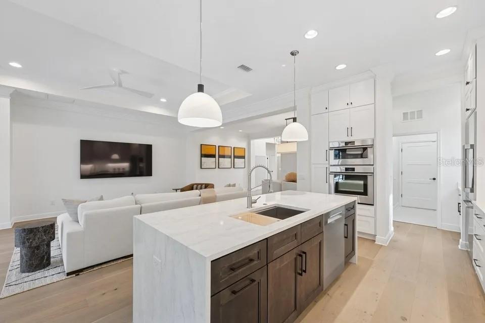 7346 Edenmore Street Lakewood Ranch, FL 34202 - Photo 10 of 70 a large kitchen with kitchen island a sink a stove and a refrigerator