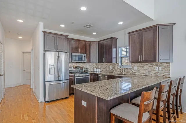 a kitchen with stainless steel appliances granite countertop a sink stove and refrigerator
