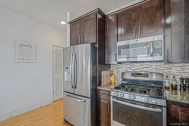 a kitchen with stainless steel appliances granite countertop a sink cabinets and wooden floor