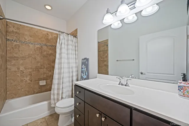 a bathroom with a sink a toilet a mirror a bathtub and shower