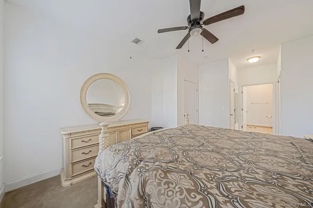 a bedroom with a bed a dresser and a chandelier