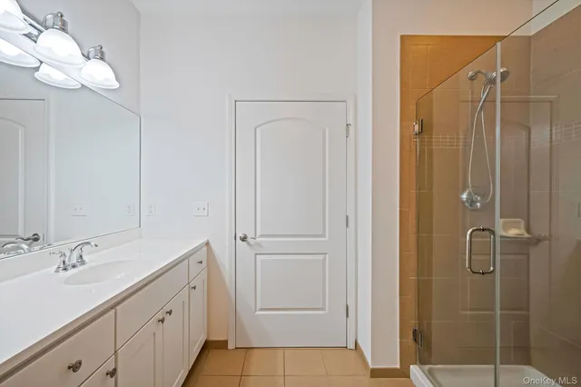 a bathroom with a double vanity sink mirror and shower