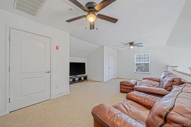 a living room with furniture a ceiling fan and a rug
