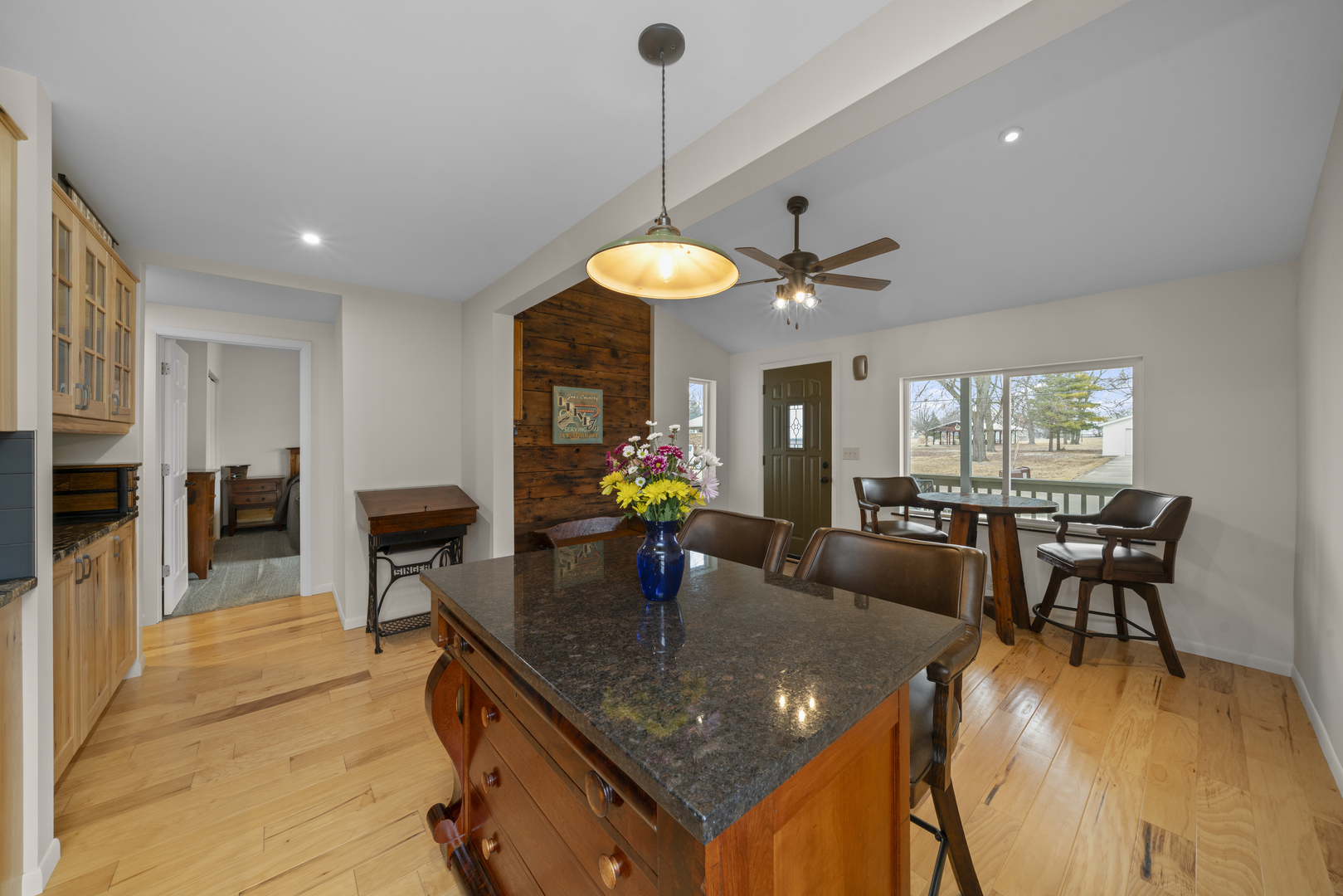 193 Chicago Road Paw Paw, IL 61353 - Photo 11 of 37 a kitchen island with stainless steel appliances granite countertop a stove a sink a dining table and chairs with wooden floor