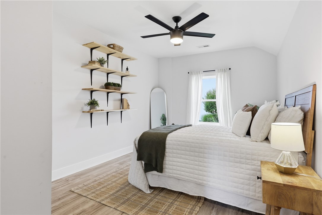 1 Brock Street Pelzer, SC 29669 - Photo 17 of 25 A cozy bedroom features a stylish ceiling fan, ample natural light, and modern shelving.