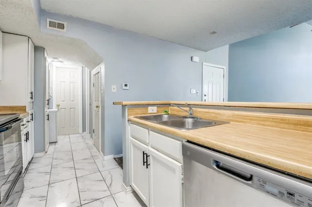 a view of a kitchen with a sink and refrigerator
