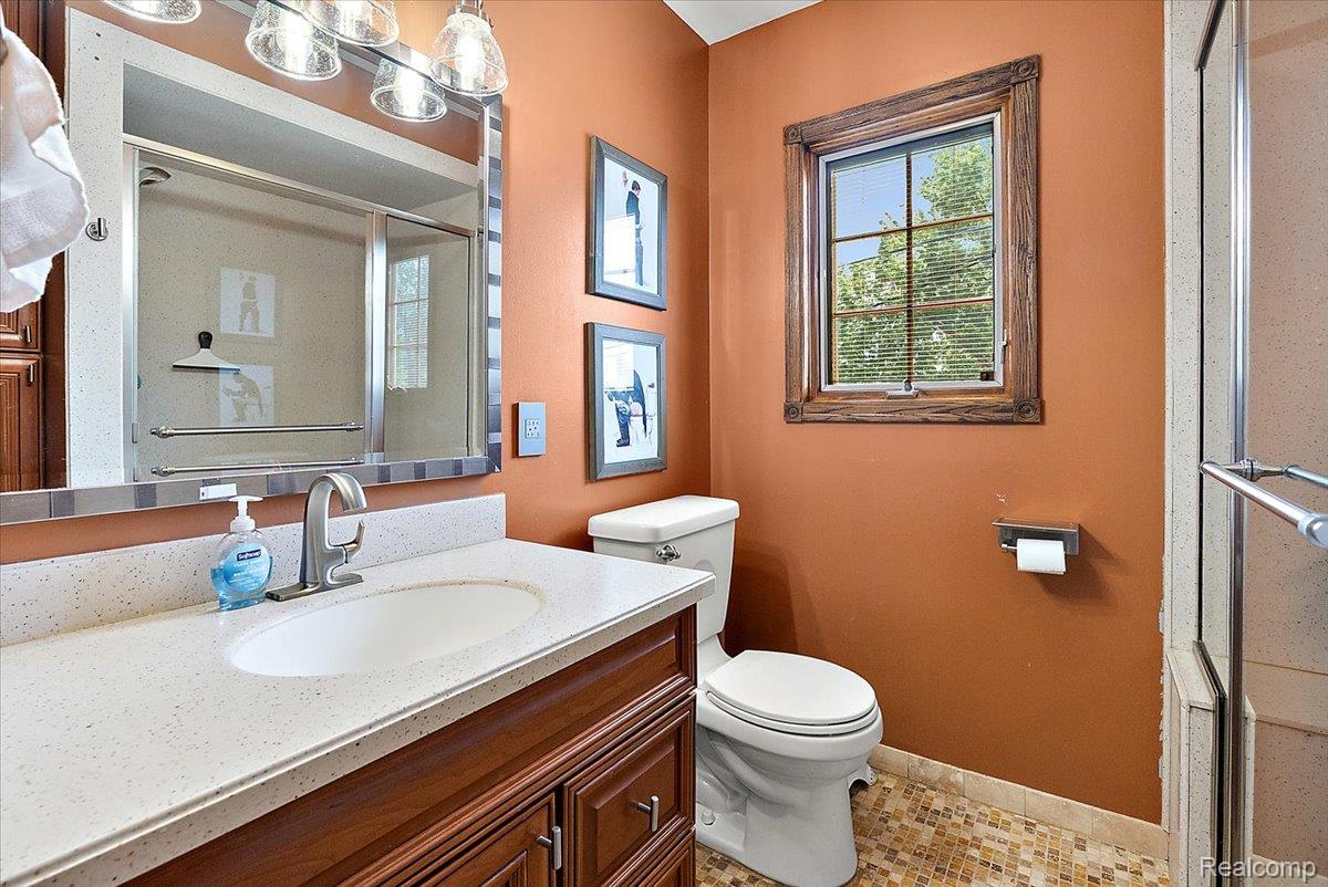60718 Campground Road Washington, MI 48094 - Photo 18 of 37 Bathroom featuring a wood-finish vanity with a light-toned countertop and an undermount sink