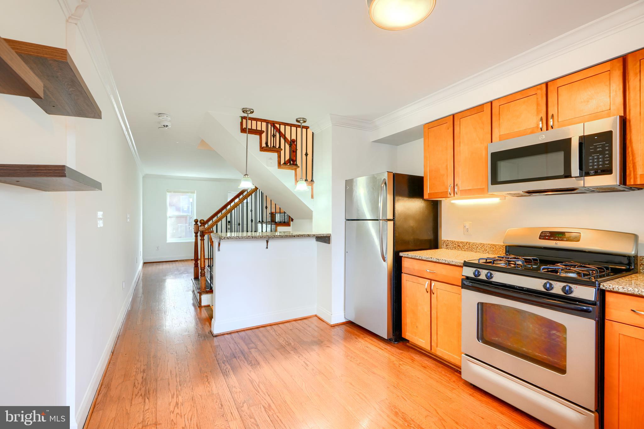 1520 Byrd Street Baltimore, MD 21230 - Photo 11 of 37 a kitchen with stainless steel appliances granite countertop a stove a microwave and a refrigerator