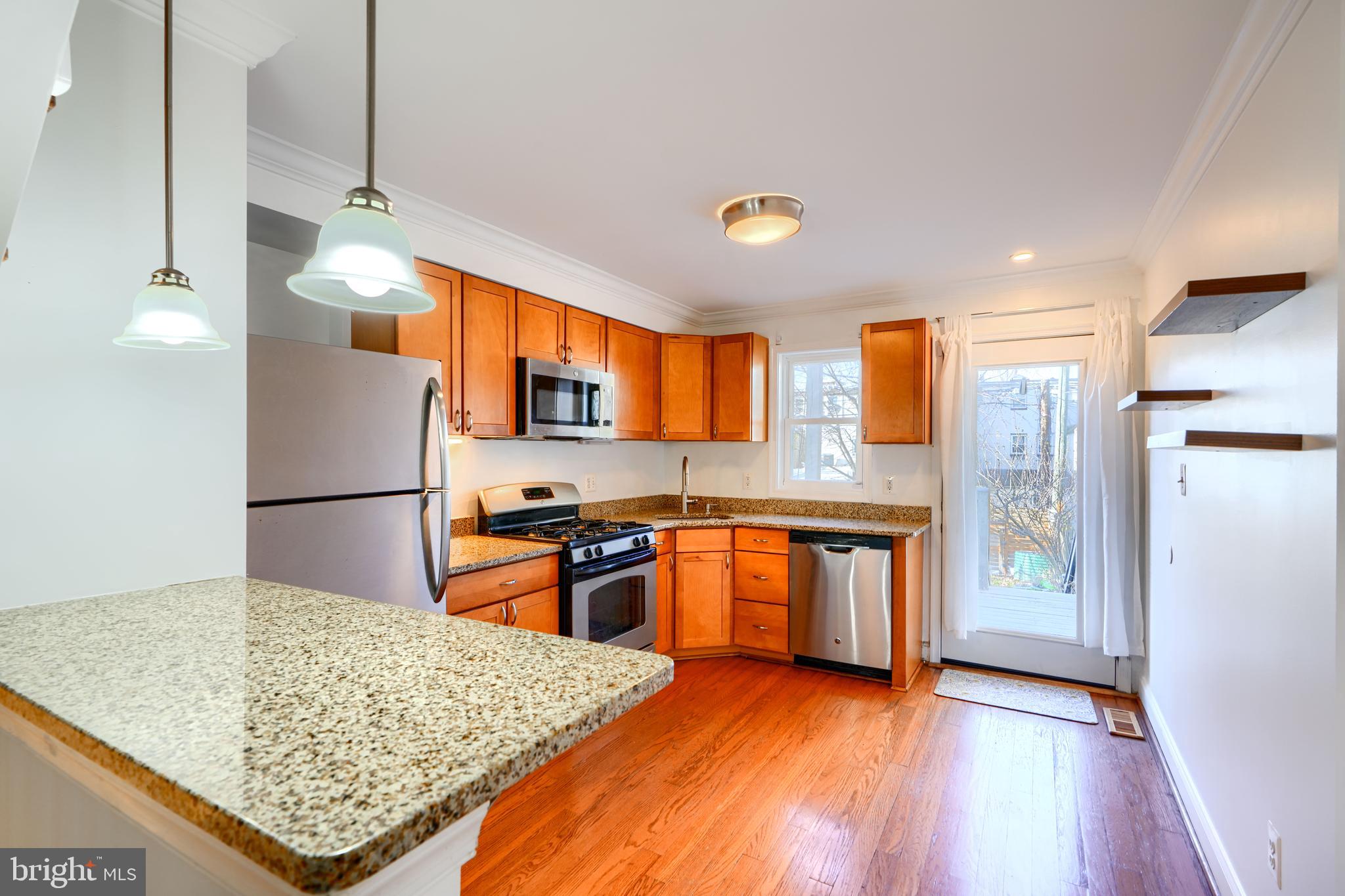 1520 Byrd Street Baltimore, MD 21230 - Photo 8 of 37 a kitchen with stainless steel appliances granite countertop a refrigerator oven stove sink and cabinets