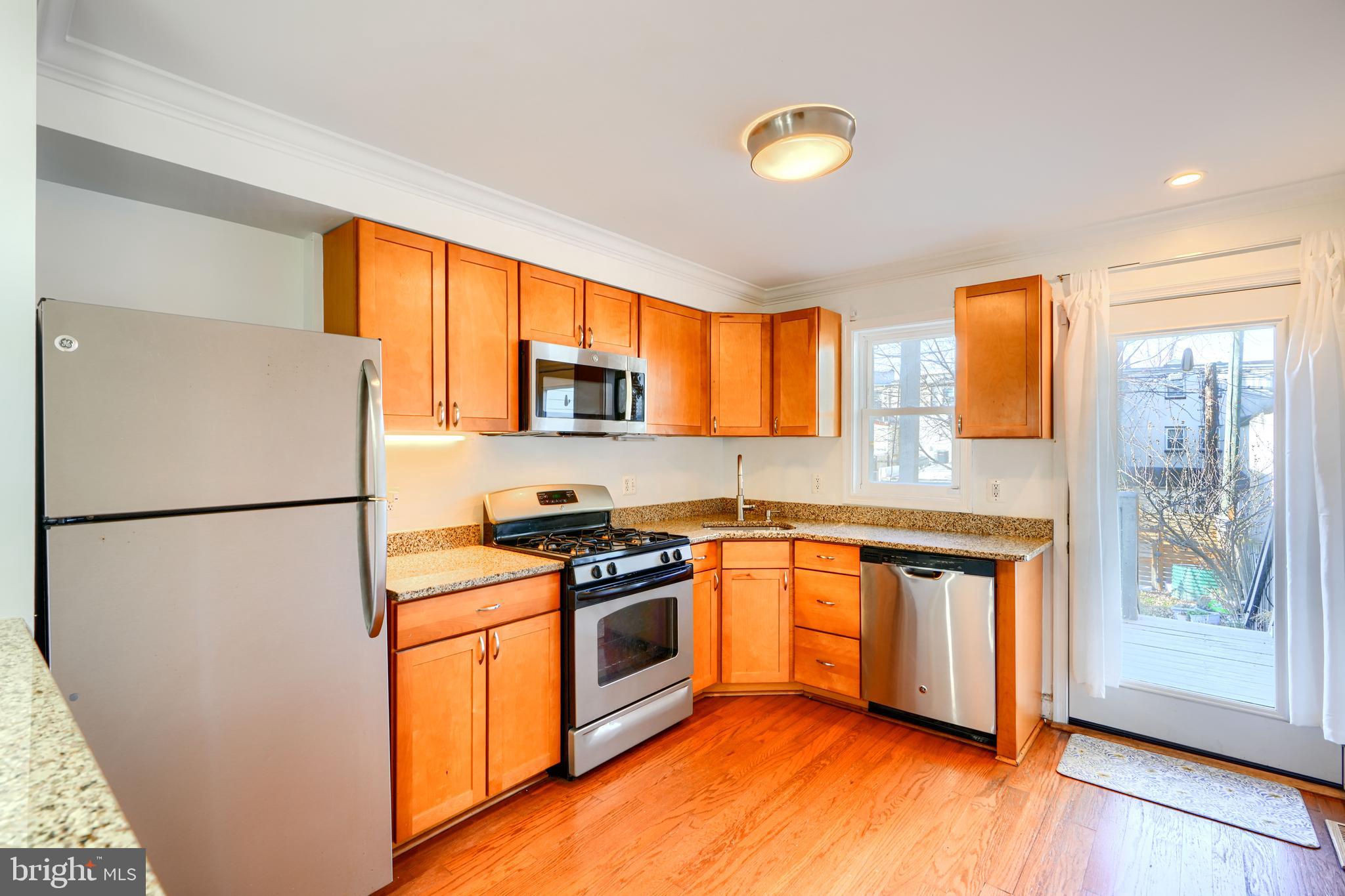 1520 Byrd Street Baltimore, MD 21230 - Photo 9 of 37 a kitchen with stainless steel appliances granite countertop a refrigerator a stove a sink a window and a microwave