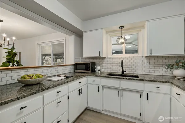 a kitchen with granite countertop a sink and cabinets