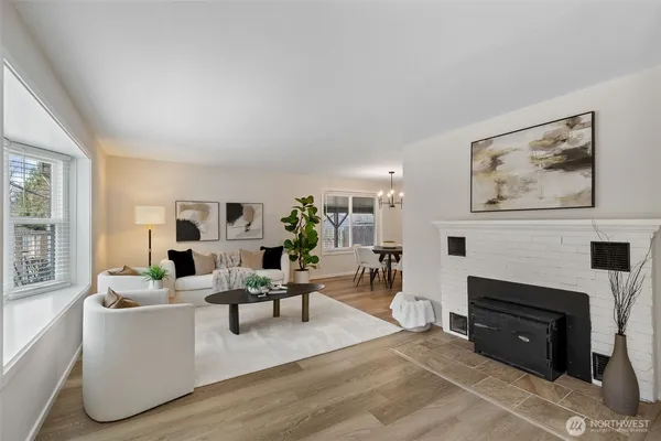 a living room with furniture a fireplace and a large window