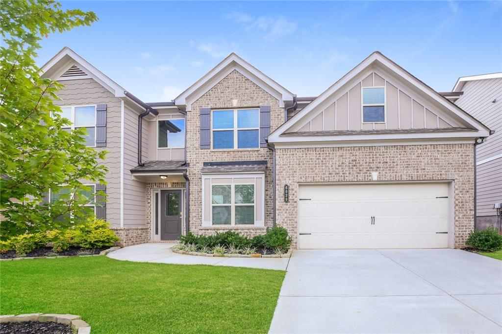 a front view of a house with a yard and garage