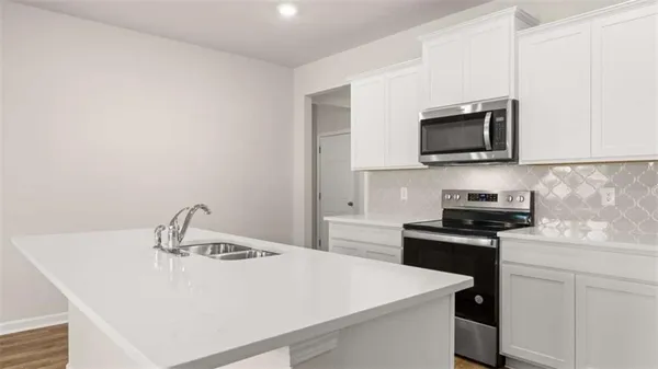 a kitchen with a sink a stove and microwave