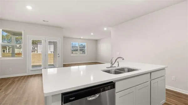 a kitchen with kitchen island a sink and wooden floor