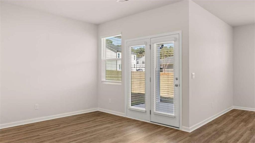 310 Friendship Oak Way Hampton, GA 30228 - Photo 14 of 41 an empty room with wooden floor and windows