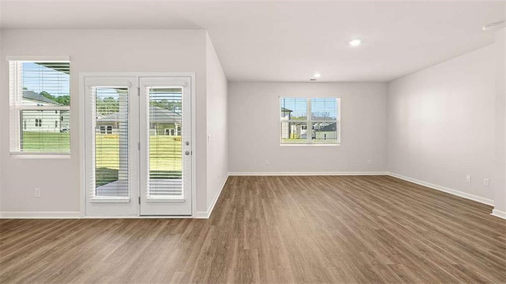 310 Friendship Oak Way Hampton, GA 30228 - Photo 16 of 41 an empty room with wooden floor and windows