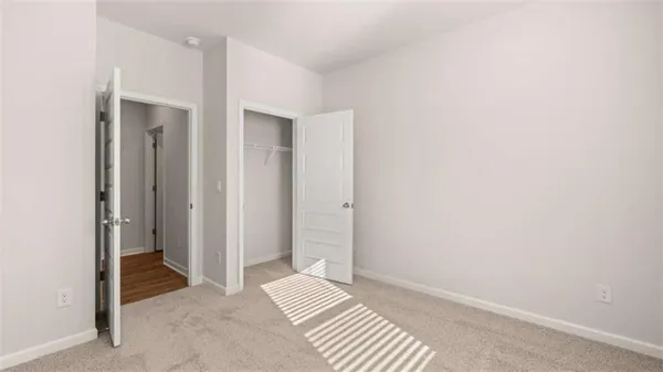 a view of room with walk in closet and wooden floor