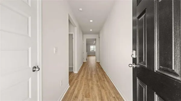 a view of a hallway with wooden floor and staircase