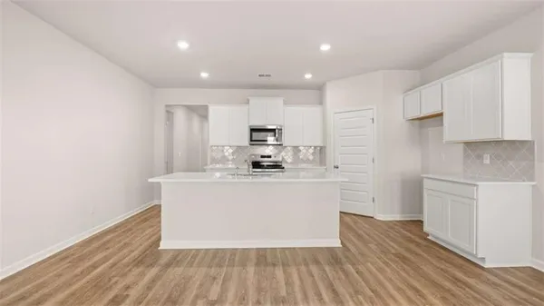 a view of kitchen with stainless steel appliances granite countertop a stove top oven a sink and a refrigerator