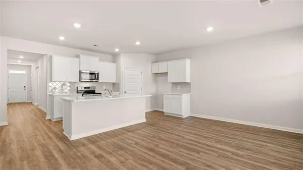 a kitchen with granite countertop white cabinets and stainless steel appliances