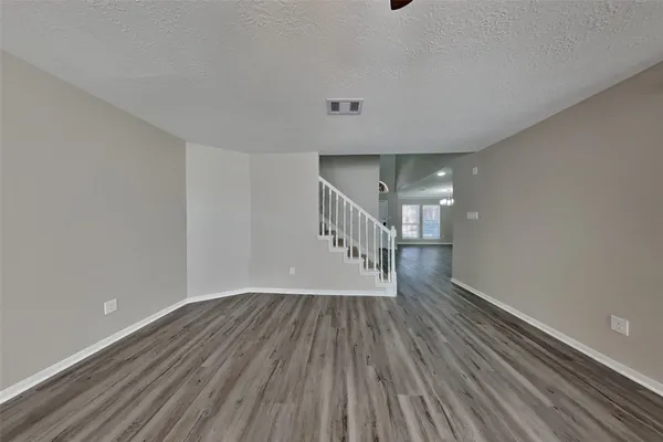 a view of room with stairs and wooden floor