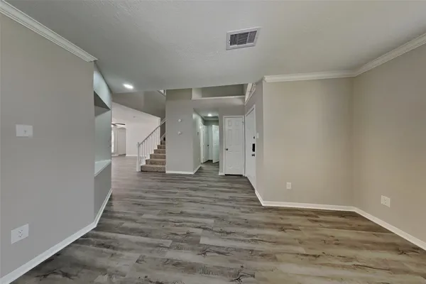 a view of an empty room with wooden floor