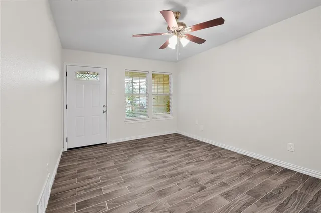a view of an empty room with wooden floor