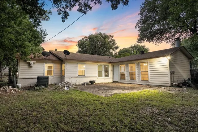 an empty room with wooden floor and fan