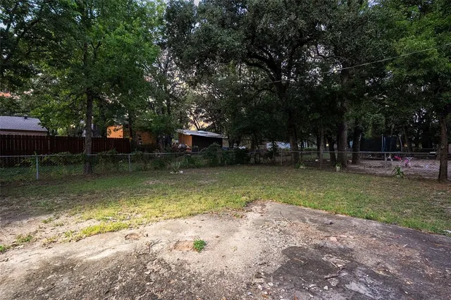 a front view of house with yard and trees all around