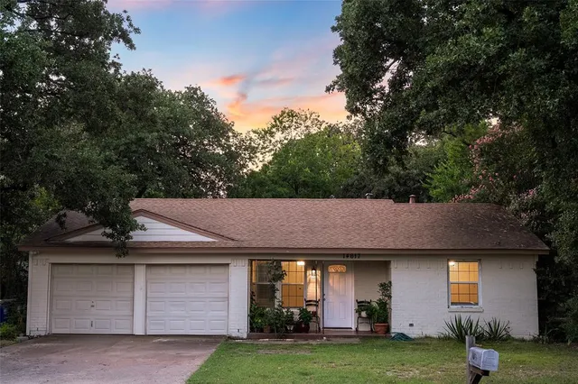 a front view of a house with a garden and yard