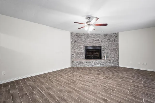 a view of empty room with wooden floor and fireplace