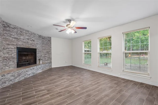 wooden floor fireplace and windows in an empty room