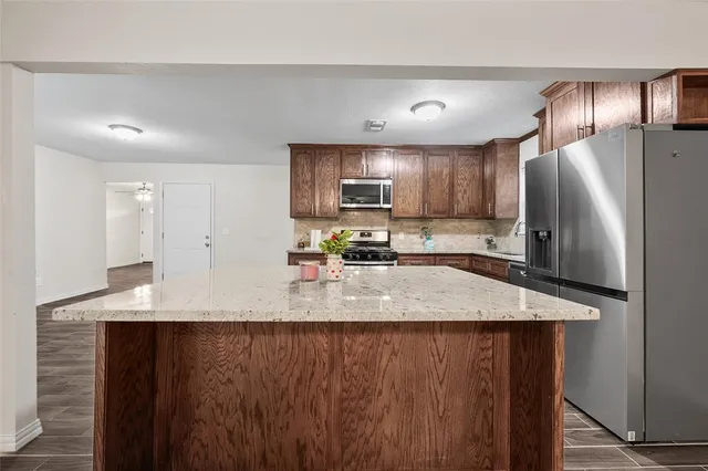 a kitchen with stainless steel appliances a refrigerator and a stove top oven
