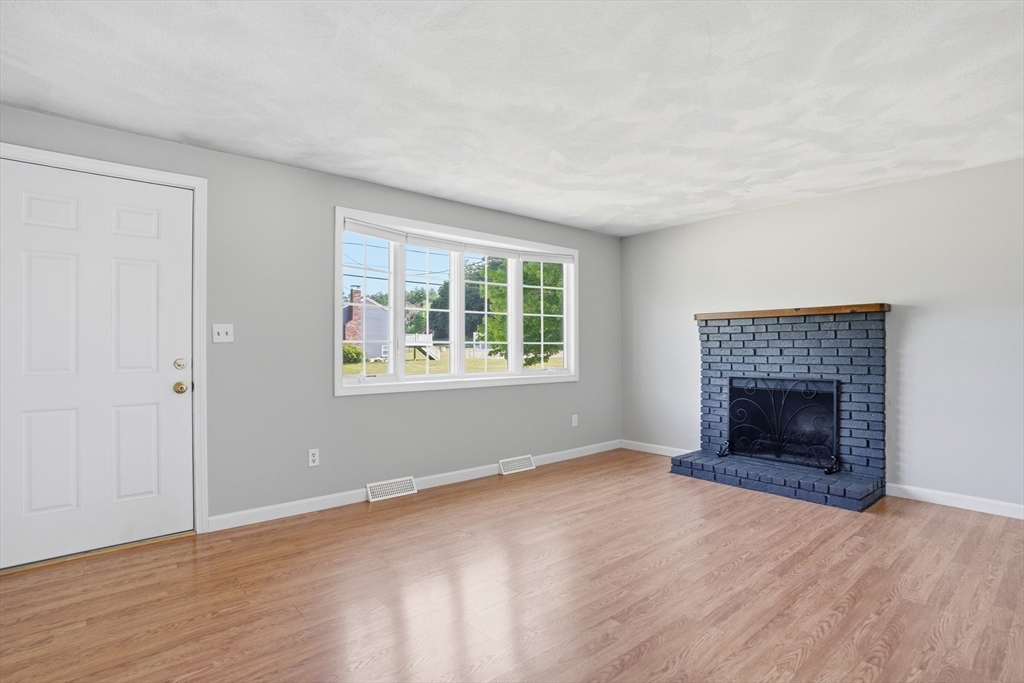 160 Navillus Road Tewksbury, MA 01876 - Photo 6 of 40 an empty room with fireplace and windows