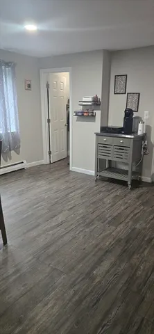 a view of a room with wooden floor and electronic appliances