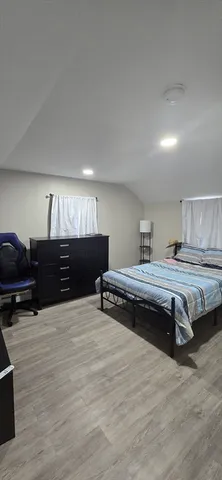 a bedroom with furniture and a wooden floor