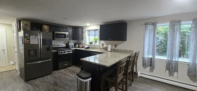 a kitchen with kitchen island granite countertop stainless steel appliances a sink stove and refrigerator