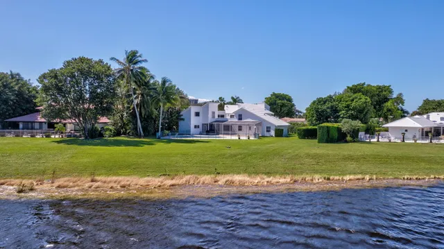 a view of a house with a big yard and large trees