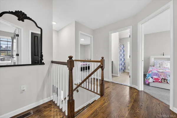 a view of a hallway with wooden floor and stairs