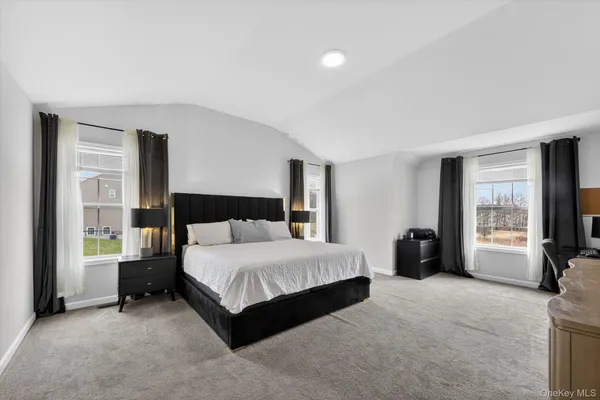 a spacious bedroom with a bed and a large window