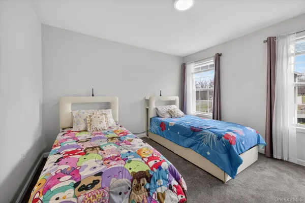 a bedroom with a bed and a lamp on a dresser