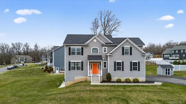 a front view of a house with a yard and trees
