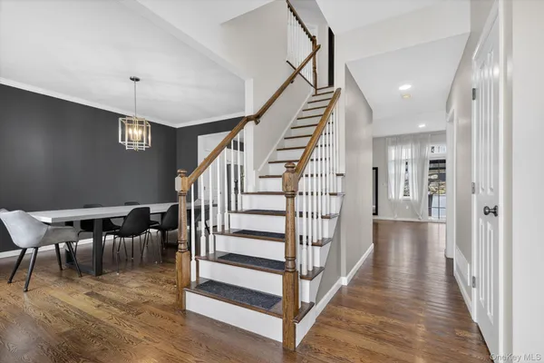 a view of a hallway with wooden floor and stairs