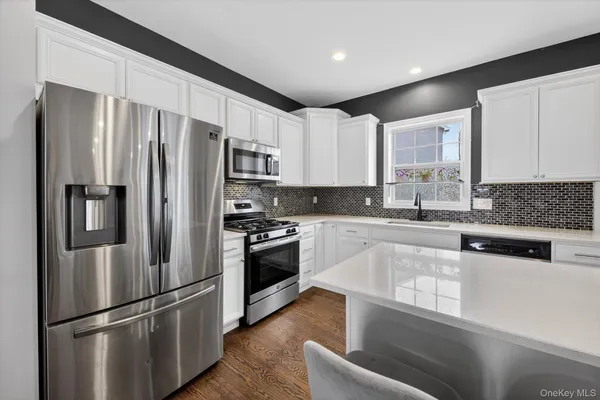 a kitchen with stainless steel appliances a refrigerator sink and microwave