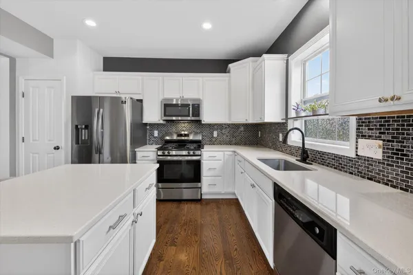 a kitchen with stainless steel appliances a refrigerator sink and cabinets