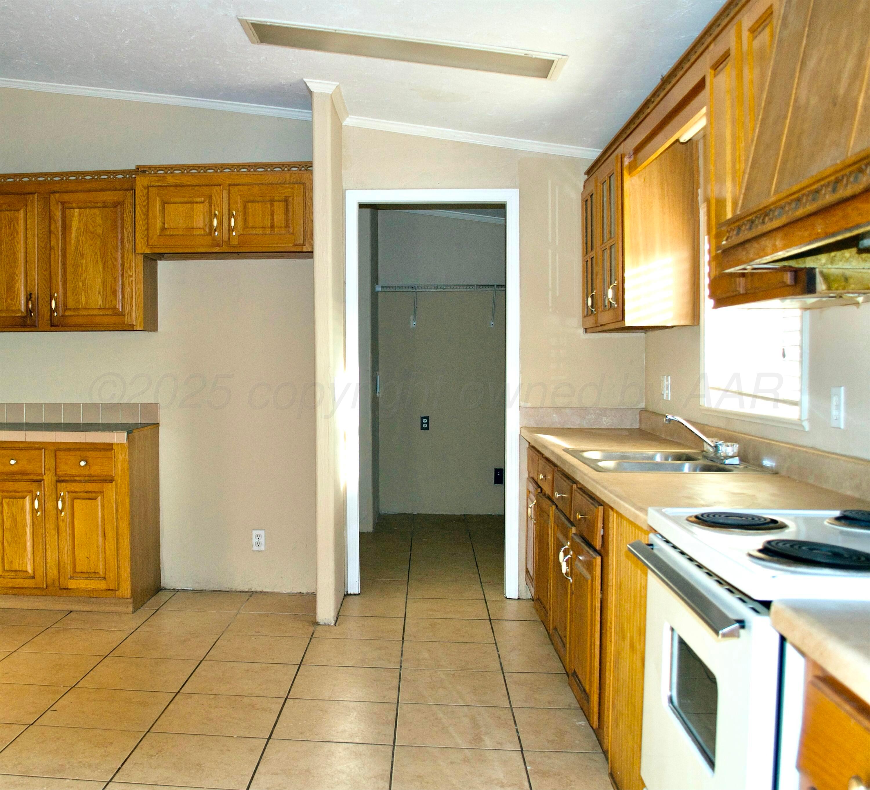 406 North Independence Street Amarillo, TX 79106 - Photo 17 of 19 a kitchen with a stove top oven cabinets and a refrigerator